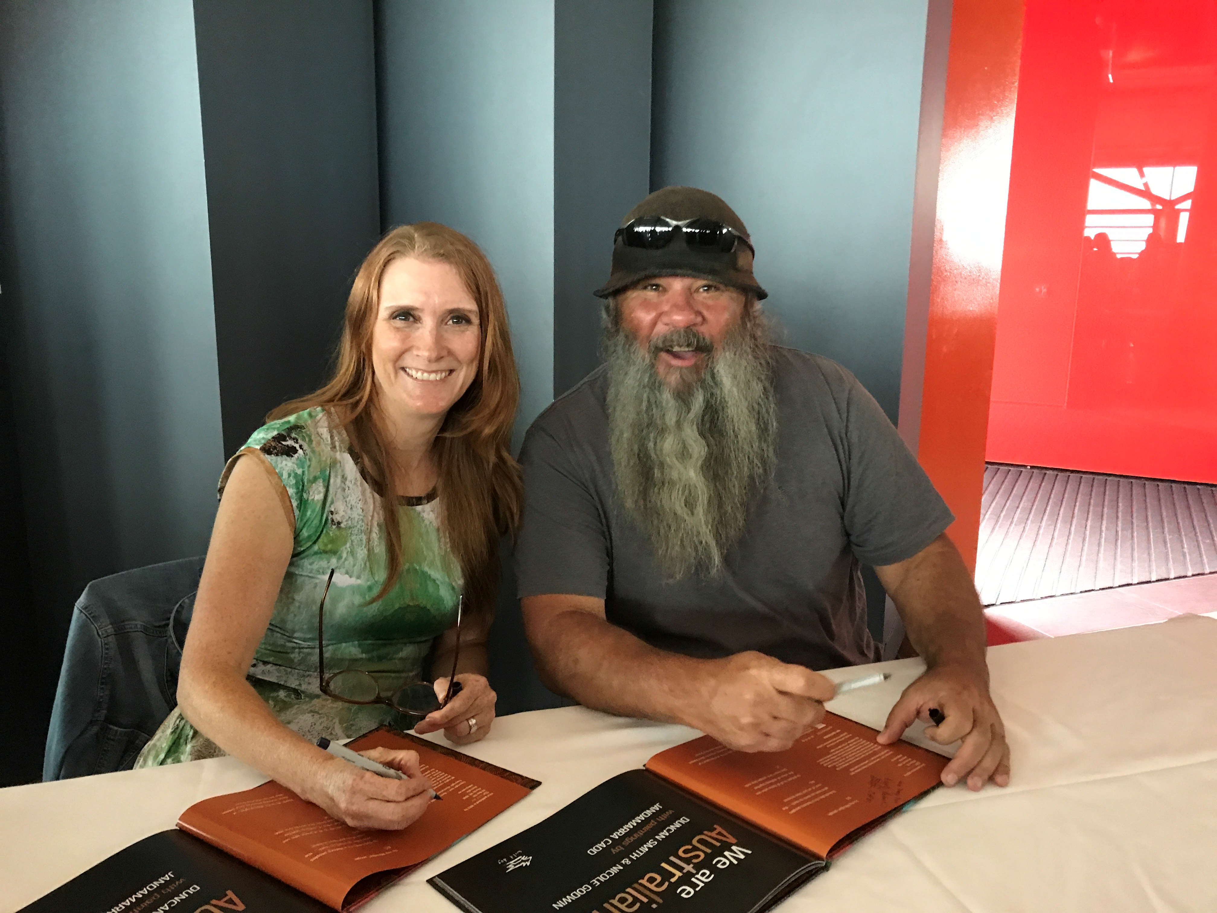 Woman and man signing books